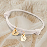 Personalisiertes PU-Lederarmband mit 2 gravierten Gold-Herz-Anhängern mit Geburtstag und Blume in Creme - gefertigt von Love & Faith