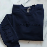 Navyblauer Pullover personalisiert mit Mamasaurus und Kindernamen als Dinofigur gedruckt von Love & Faith