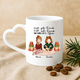 Weiße personalisierte Weihnachtstasse mit Herzhenkel  mit Freundinnen-Illustration für Glühwein zur Weihnachtsfeier als Geschenk von Love & Faith