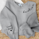 Grauer Sweater mit Mama Schriftzug und Kindernamen auf dem Ärmel - Personalisiertes Geschenk von Love & Faith